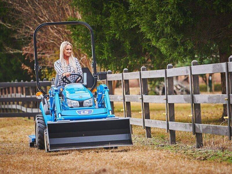 Extensive Field Maintenance with Riding Mower Outdoor maintenance worker riding a mower across a large field.