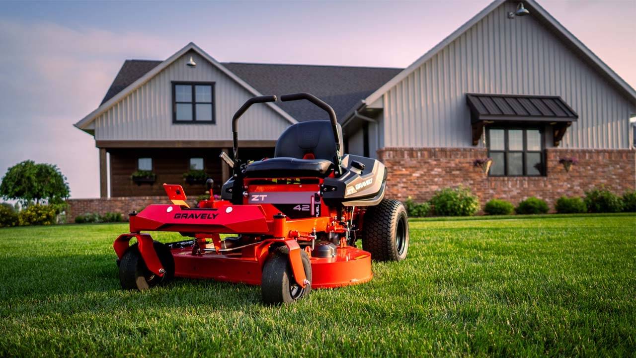 Man trimming the grass with a gas lawn mower.